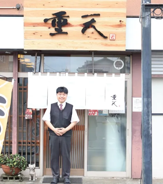 店舗の前に立つ店主