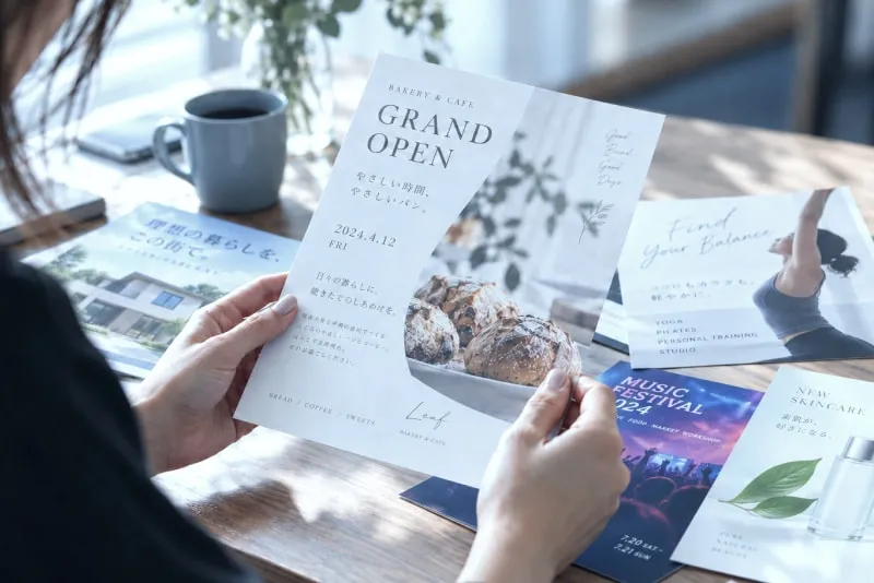 グランドオープンのチラシを手に取る様子
